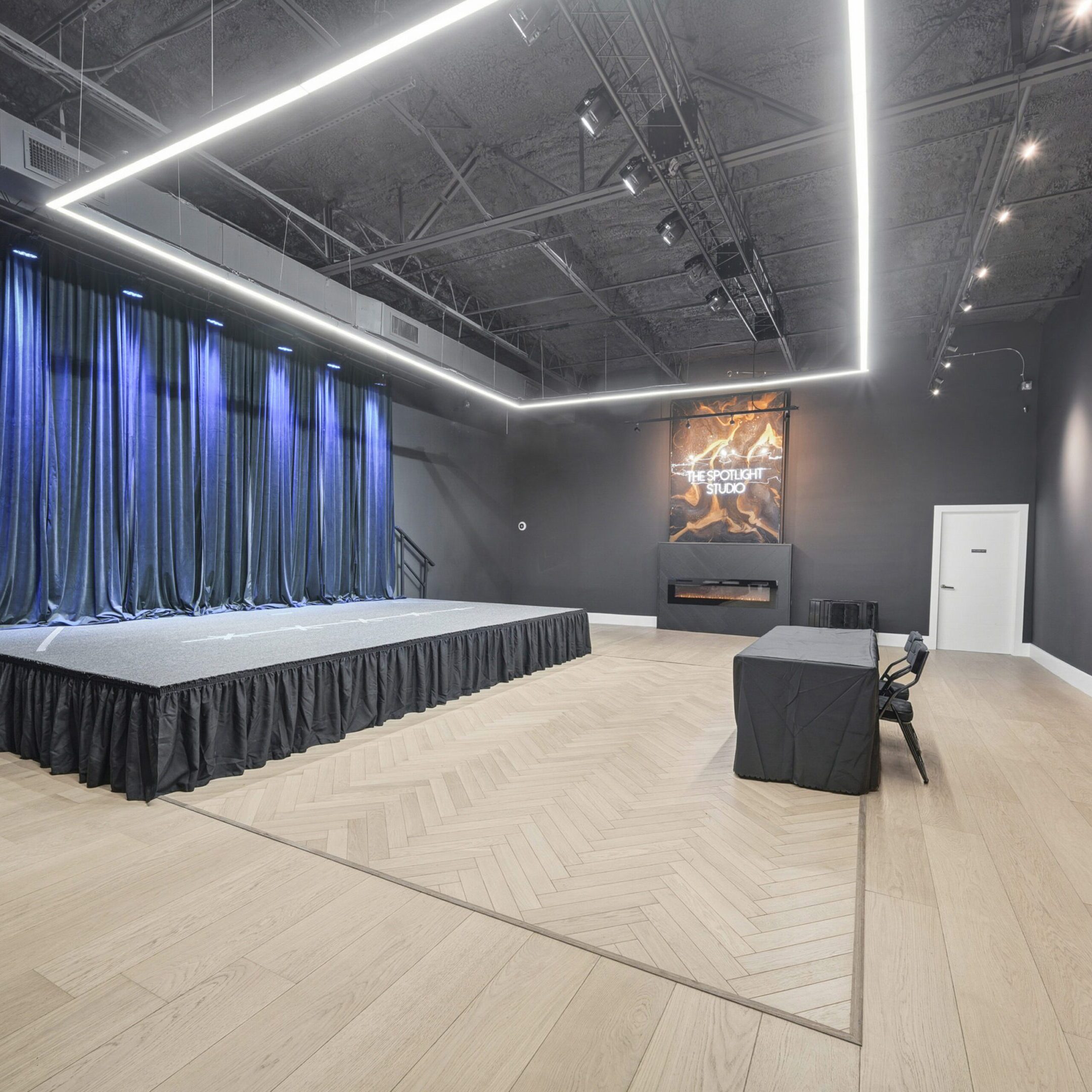 Modern conference room with stage, seating, and ambient lighting.